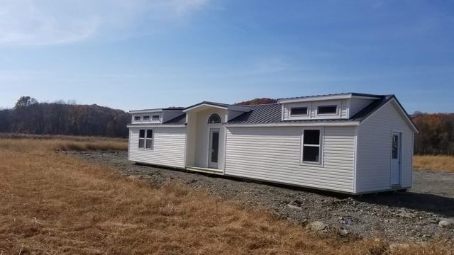 White vinyl cabin with twin dormers