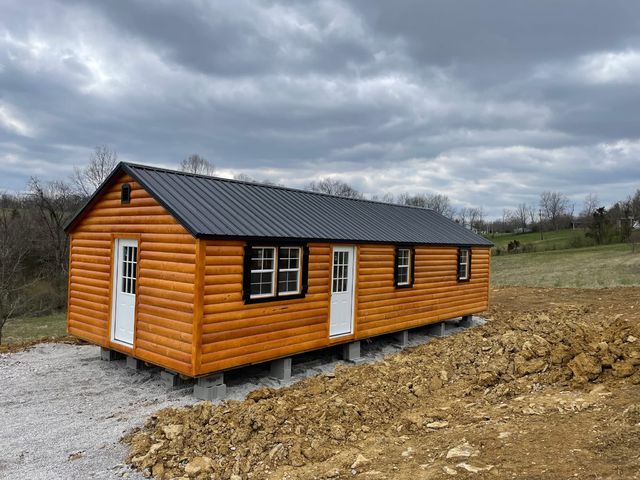 Log-sided cabin with metal roof on a prepared site